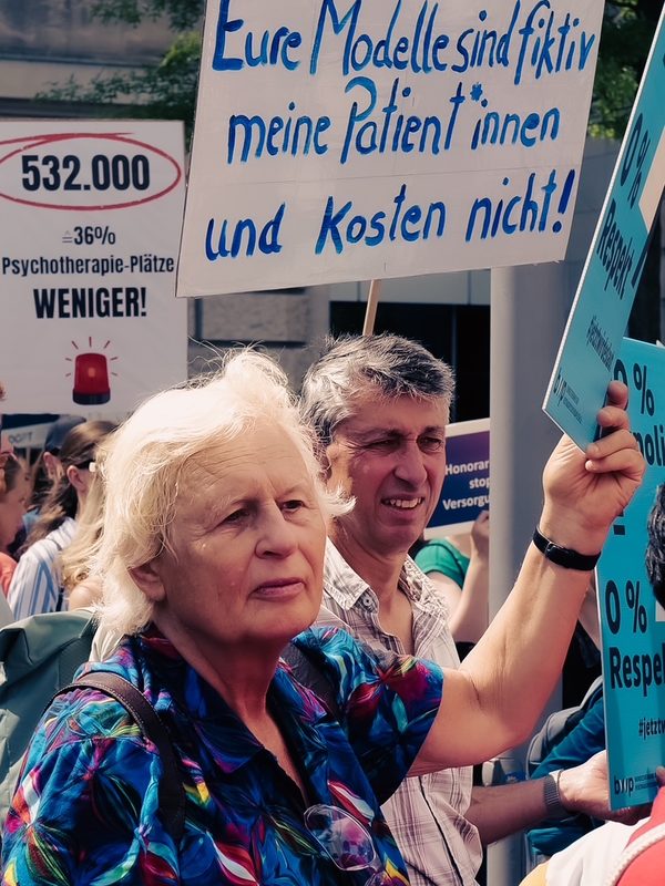 Demonstrierende mit Schild: Eure Modelle sind fiktiv