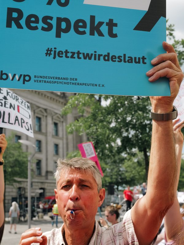 Demonstrant mit Trillerpfeife und Protestschild